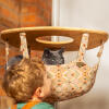 Gato que mira hacia fuera de una hamaca interior del árbol del gato de Freestyle con el niño pequeño