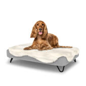 Perro sentado en la cama para perros de espuma con memoria Topology con topper de piel de oveja fácil de limpiar y patas de horquilla negras