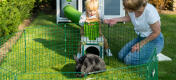 Familia jugando con su conejo mascota dentro de un corralito de Zippi.