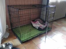 Una jaula de transporte para un perro hecha de malla metálica