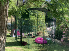 Un gran recinto para conejos en un jardín verde