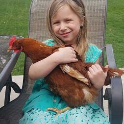 Chica sosteniendo un pollo