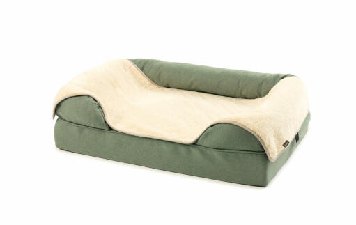 Manta de felpa gris y de piel sobre una cama de cojín verde 36
