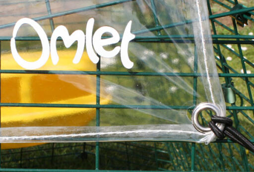 Primer plano de la cubierta transparente Omlet y de las cuerdas elásticas en un corral de pollos Eglu Cube 