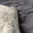 La manta es reversible, por un lado cuenta con un elegante acolchado gris y por el otro un sherpa en color crema