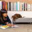 Perro investigando un libro mientras está en la cama para perros Topology de Omlet con funda acolchada y patas de raíl negras