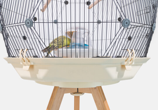 La jaula para pájaros Geo con una base de color crema