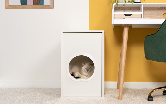 El gato descansando en la modernaa casa para gatos, un espacio cerrado que reduce las corrientes de aire y ruidos del hogar.